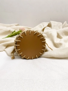 Handmade woven cotton rope beach bag with brown leather base and drawstring closure