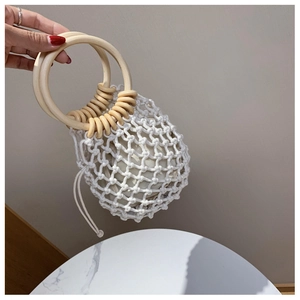 Detailed close-up of woven cotton rope bag featuring wooden ring handles and drawstring liner