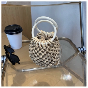 Detail of hand-woven cotton rope bucket bag with round handles and drawstring liner