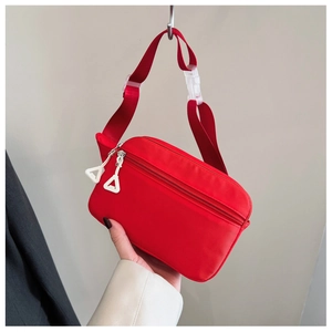 Detail der roten Nylon-Gürteltasche mit weißem Reißverschluss und verstellbarer Schnalle