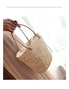 Detail of handmade beige straw bucket bag featuring tight weave and drawstring liner