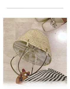 Detail of handmade straw bucket bag with canvas drawstring liner and slim leather handles