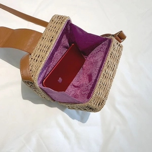 Detail of woven straw bag interior featuring mandala print lining and phone compartment