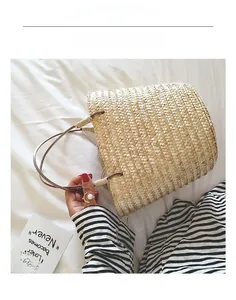 Detailed close-up of woven straw handbag handle with bohemian textured pattern