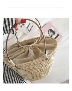 Top view of handmade straw bucket bag with linen drawstring liner and leather handles