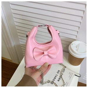 Detailed close-up of a mini pink girl's bag with a bow accent and metal ring handle