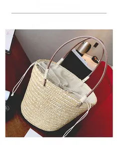 Close-up of handmade straw bucket bag with drawstring liner and purple handles