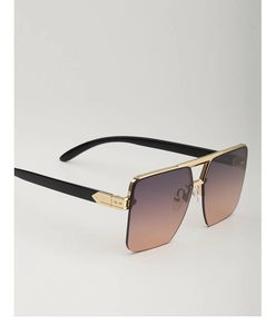 Detail view of large square sunglasses with gold metal frame and gradient lenses
