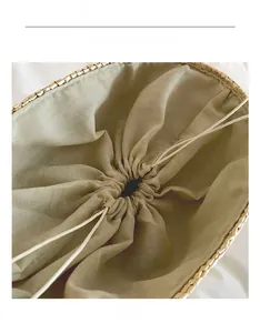 Detail of handmade straw bag featuring light green linen lining and drawstring closure