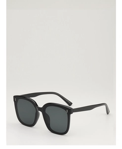 Gros plan de lunettes de soleil carrées noires avec rivets en métal et verres sombres