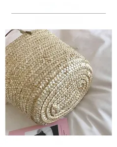 Detailed close-up of natural straw bucket bag showing intricate hand-woven fiber texture