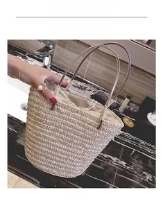 Close-up of handmade straw bucket bag with drawstring liner and dual woven handles