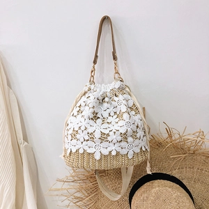 Summer straw bucket bag with white lace floral overlay and brown crossbody strap