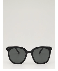 Vue détaillée de lunettes de soleil noires oversize avec doubles rivets métalliques