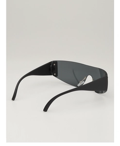 Détail de lunettes de soleil Y2K sans monture avec larges branches noires et verres gris