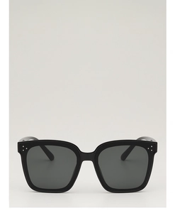 Vue avant de lunettes de soleil carrées noires avec rivets métalliques et verres foncés