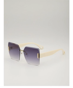 Close-up of wide cream temples with gold metal hinges on rimless gradient sunglasses