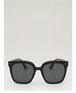 Détail de lunettes de soleil carrées noires avec rivets argentés et verres gris foncés