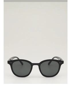 Vue de face de lunettes de soleil noires oversize avec verres polarisés gris et rivets