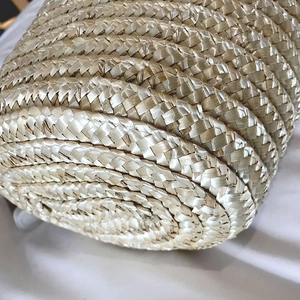 Handmade bohemian straw bucket bag showing detailed spiral woven base for summer vacation