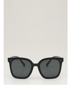 Détail de lunettes de soleil carrées noires avec triple rivets argentés sur la monture