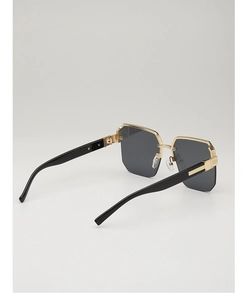 Detailed side view of stylish gold-rimmed polygonal sunglasses with grey gradient lenses