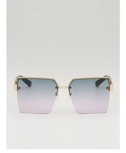 Macro detail of oversized square sunglasses with gold metal frame and gradient lenses