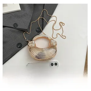 Close-up of champagne gold acrylic clutch bag with textured stripes and ring handle