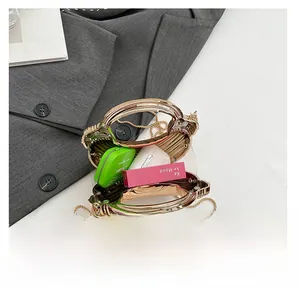 Detail showing the inner capacity of a gold shell-shaped clutch with gold chain
