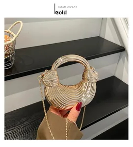 Detailed view of a round gold metal evening bag with unique spiral pleated texture