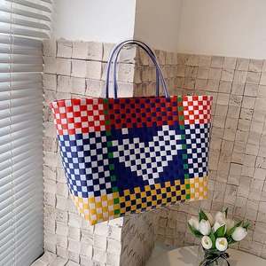 Detail showing multi-color woven tote bag with heart pattern in natural sunlight