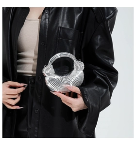 Detailed view of silver metallic crescent bag with sculptural stripes and ring handle