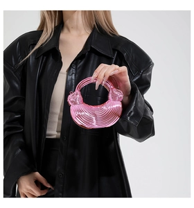 Detail of metallic pink acrylic mini bag featuring coiled spiral texture and arc handle