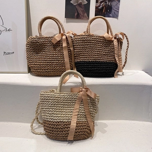 Detail of straw woven tote bags with silk scarves on white steps for a vacation vibe