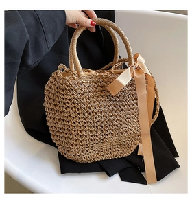 Detail view of woven straw tote bag with silk bow and rigid round handles
