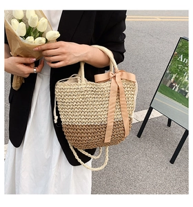 Detail of two-tone straw tote bag with pink satin bow and drawstring lining