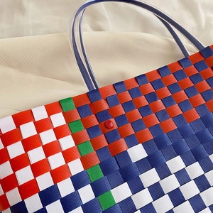 Close-up of multicolored woven tote featuring plaid pattern and transparent handles