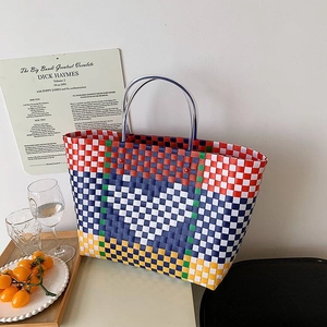 Macro detail of multi-colored checkered woven plastic basket featuring white heart pattern