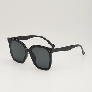 Lunettes de soleil noires à monture large, design carré moderne avec accents de rivets