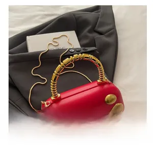 Detail of red PU leather handbag with golden beaded handle and metal studs on a suit