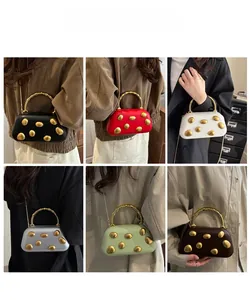 Detail view of multi-color PU hardshell evening bags with gold spiral handle and chain