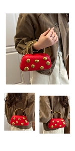 Macro detail of red hardshell bag with artistic gold pebble ornaments and beaded handle