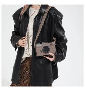 Détail d'un sac bandoulière rétro en forme d'appareil photo porté par un mannequin