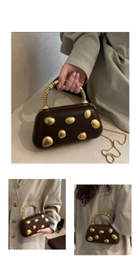 Detail of matte brown handbag with pebble-shaped gold accents and spiral metal handle