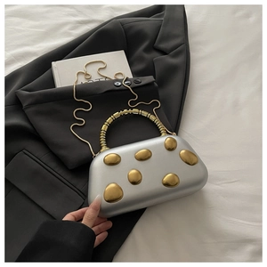Detail of silver evening hard shell bag with gold pebble accents and bead handle
