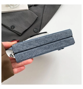 Détail d'un sac bandoulière en denim en forme d'appareil photo rétro avec métal argenté