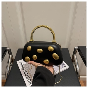 Detailed shot of a black PU leather box bag with irregular gold hardware and metal handle