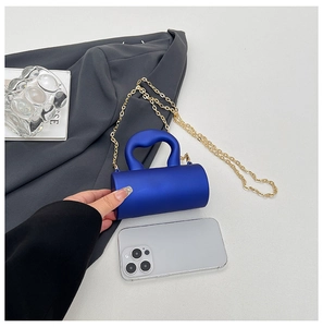 Mini sac cylindrique bleu électrique à côté d'un smartphone montrant sa taille compacte