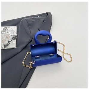 Détail du mini sac rigide bleu klein avec chaîne dorée et charnière métallique