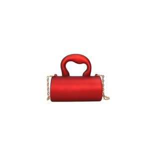 Mini sac cylindrique rouge avec texture mate et bandoulière en chaîne dorée amovible